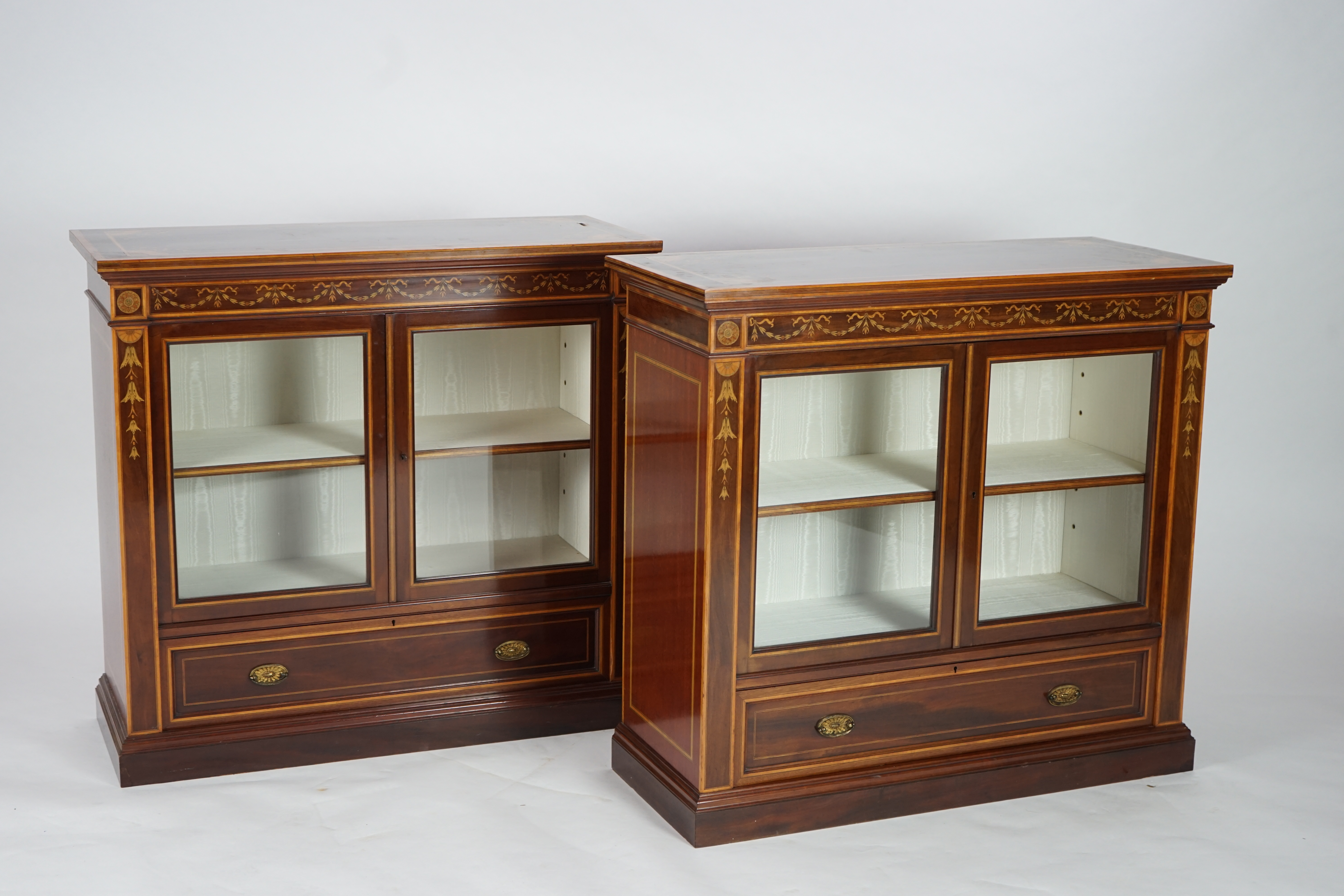 A pair of Edwardian marquetry inlaid and satinwood banded mahogany side cabinets, by Gillows